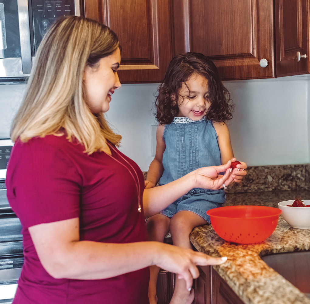 A mother and daughter spending time together in the kitchen, preparing food and bonding.